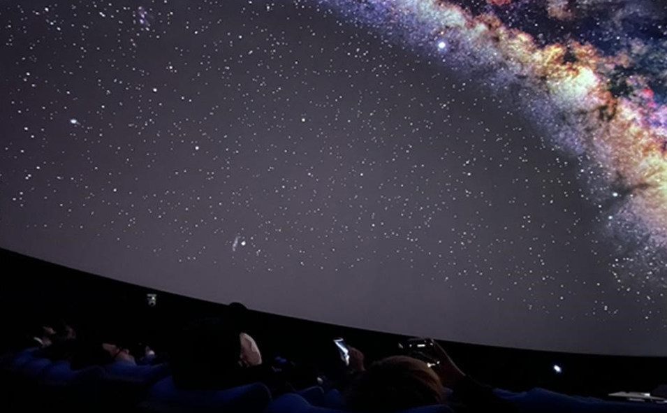 The audience is taking pictures of the projected Milky Way