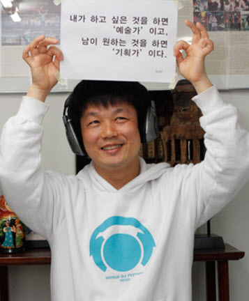 Director Ryu is holding a sign states “Artists make what they want, and planners make what others want”