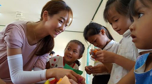 A student at the College of Education is teaching Laos children in Xiangkhouang