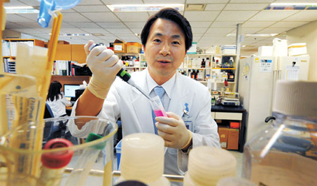 Dr. LEE Choon-Taek, the director of SNU Bundang Hospital Immunotherapy Research Center, is using a pipette to transfer a chemical reagent needed for culturing immune cells.