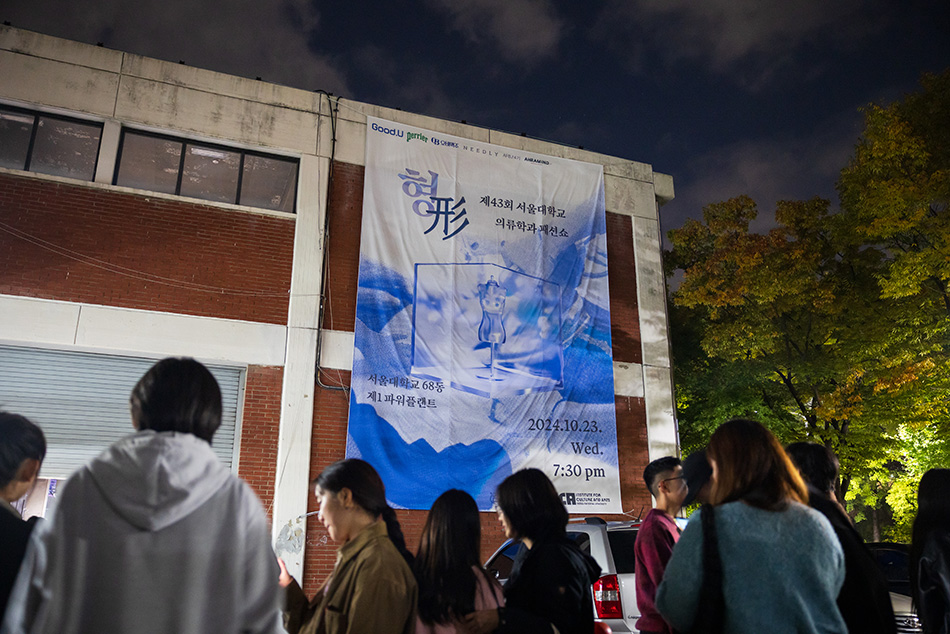 The building's exterior is decorated with a large poster advertising a fashion show.