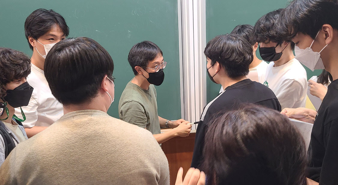 Professor Huh speaking to students after the lecture