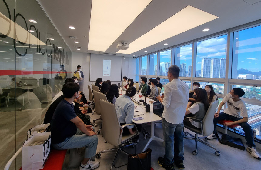 Students listening to an alumni presentation at the Hyperlounge office