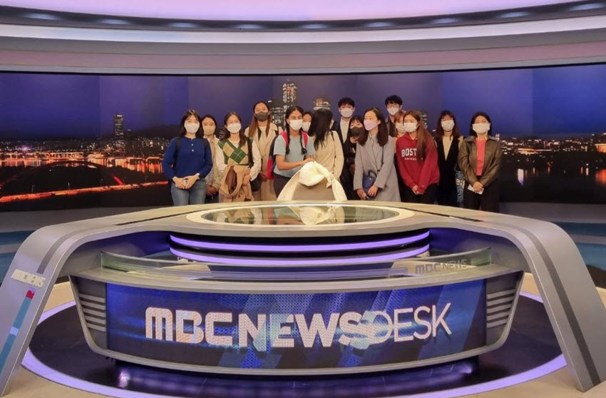Students taking a group photo at the MBC Newsdesk