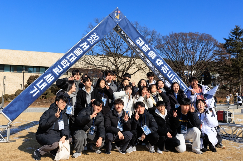 Freshmen and mentors taking a photo in front of the Freshmen Orientation installation